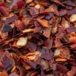 Detailed macro shot of dried crushed red pepper flakes, vibrant and spicy.