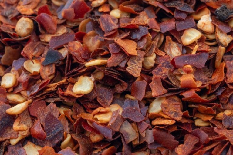Detailed macro shot of dried crushed red pepper flakes, vibrant and spicy.